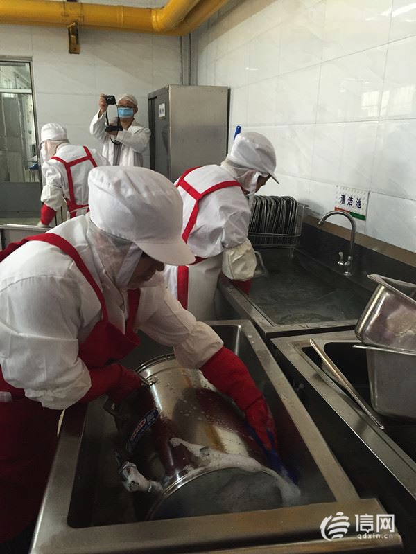 工作人员在对餐具进行清洗消毒