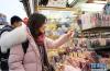 　2月8日，在日本东京，中国游客在浅草的商店街选购商品。 虽然中国人过春节的传统是返乡回家，但越来越多的国人选择在春节期间走出国门，利用春节假期外出旅游。 新华社记者 杜潇逸 摄
