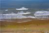 山东青岛西海岸新区银沙滩海浪漫卷沙滩，一层层叠浪向着海岸的沙滩上奔涌，摩托艇在海中戏浪，从高空俯瞰美如画卷。图片来源：视觉中国
