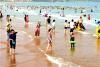山东青岛西海岸新区金沙滩海水浴场，小朋友在海水里玩耍。小朋友在海水中戏水。来源：视觉中国