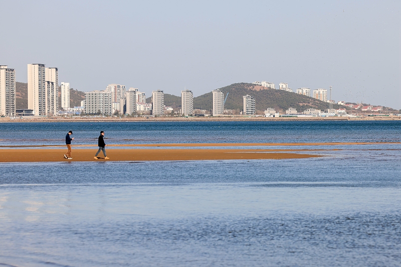 灵山湾海滨碧海蓝天 游客海滩上赏景游玩