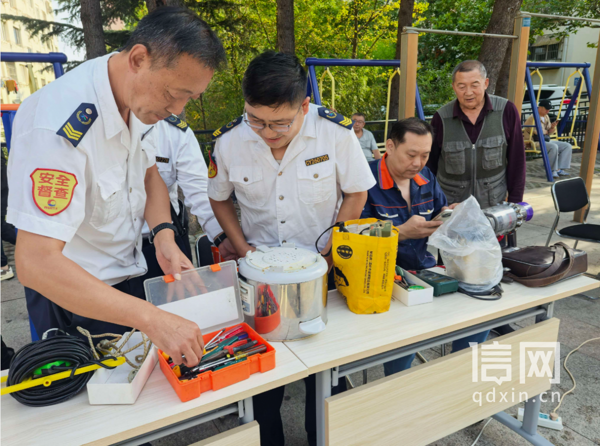 志愿者李滨、王明光、张健（从左至右）为居民维修小家电。（来源：信网）