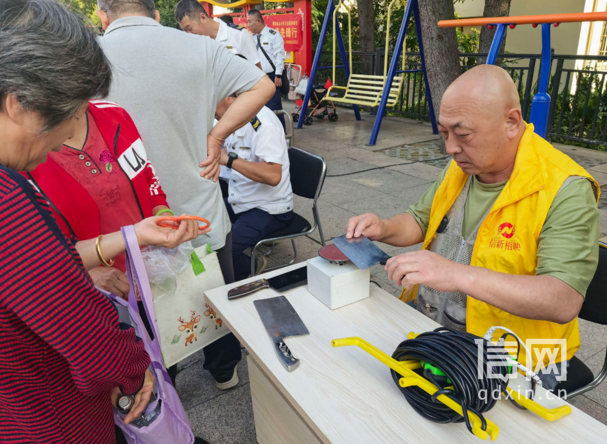 志愿者陈建伟为居民磨刀。（来源：信网）