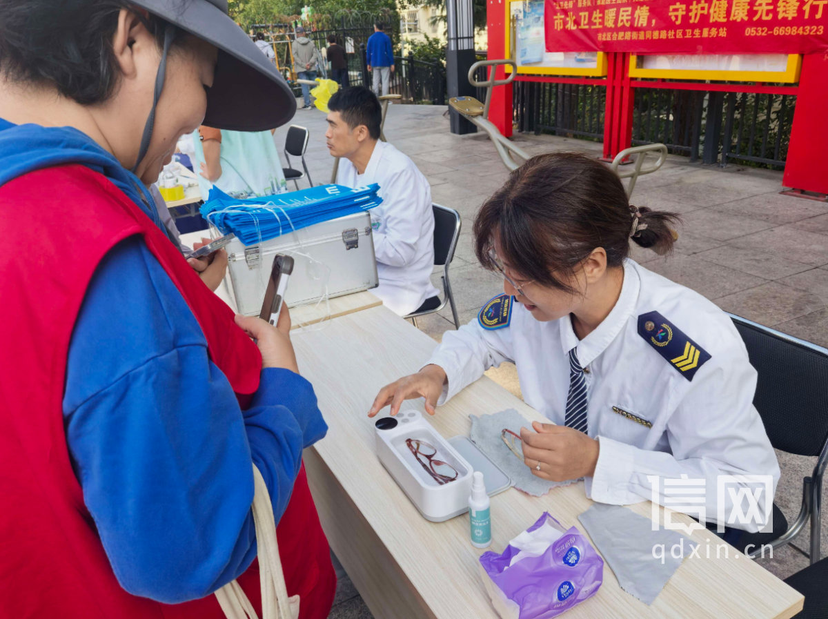 志愿者解玮玮为居民清洗眼镜。（来源：信网）