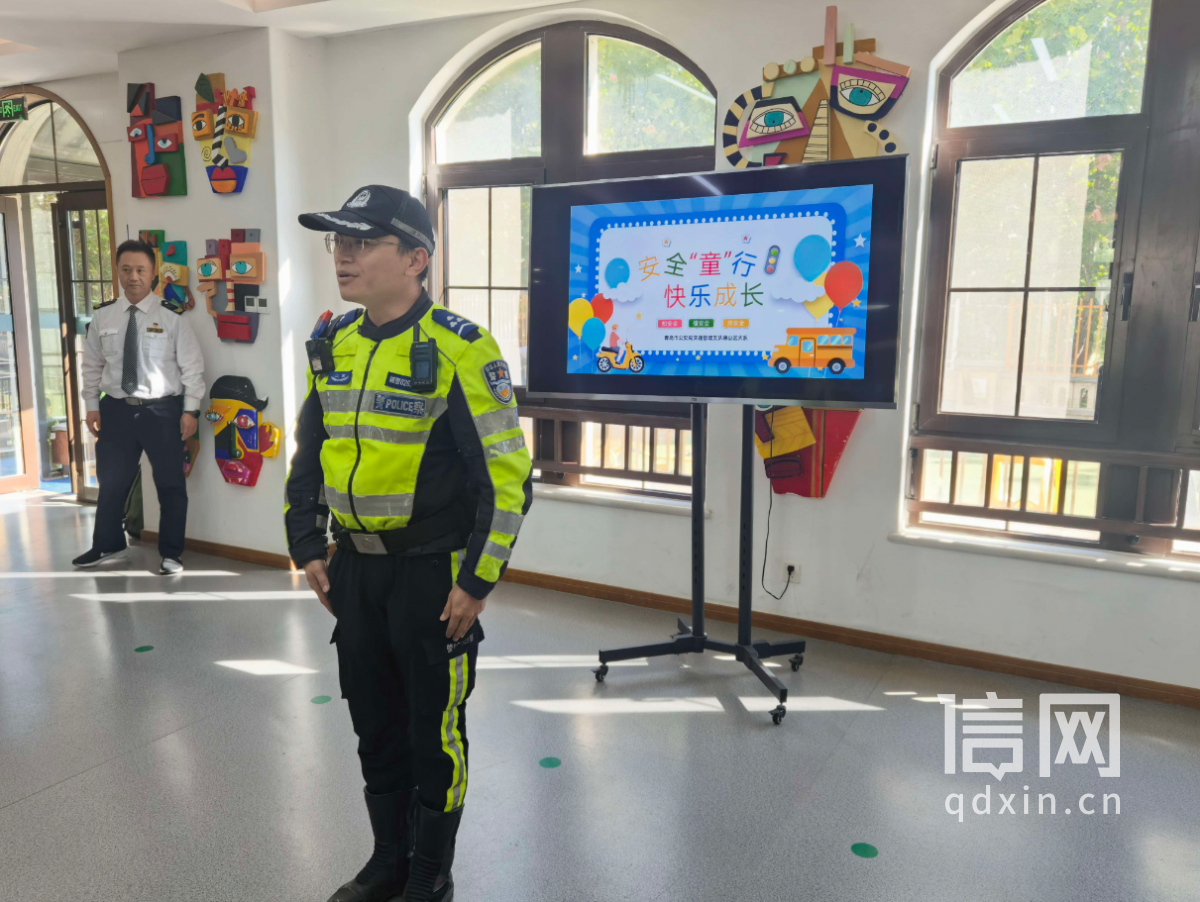 青岛市公安局交通管理支队崂山区大队一中队的铁骑队员田坤为小朋友讲解交通规则（来源：信网）