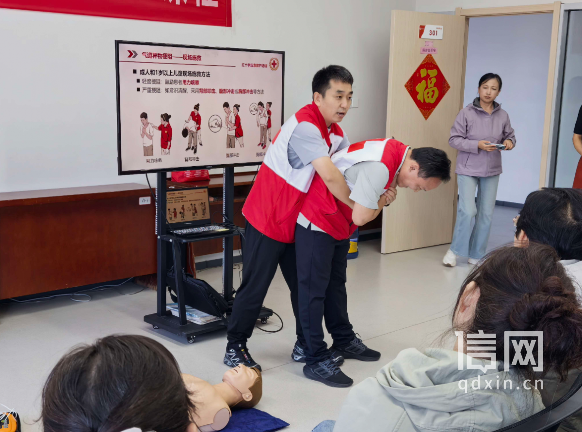 张丙良（后）、林辉（前）为居民演示海姆立克急救法（来源：信网）