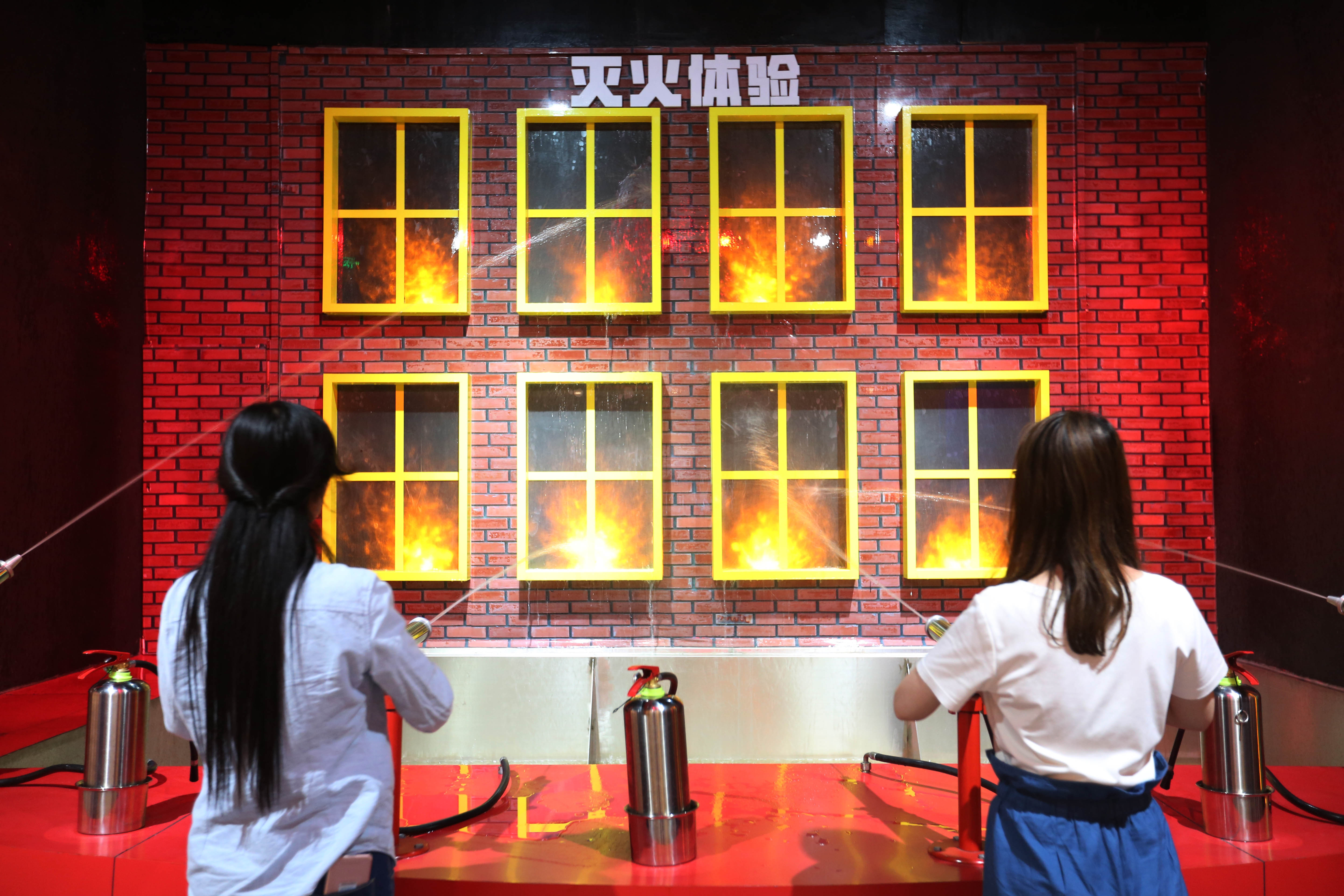 职工在青岛西海岸新区应急安全体验教育基地参与消防灭火项目体验