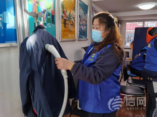 志愿者为居民提供衣物熨烫服务。 (来源：信网 首席记者 丛黎 摄)