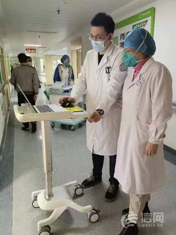 王会宇医生和同事对接患者情况。(来源：信网 首席记者 丛黎 摄)