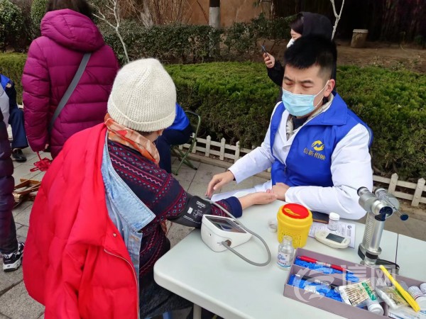 志愿者为居民提供测量血压服务 (来源：信网 首席记者 丛黎 摄)