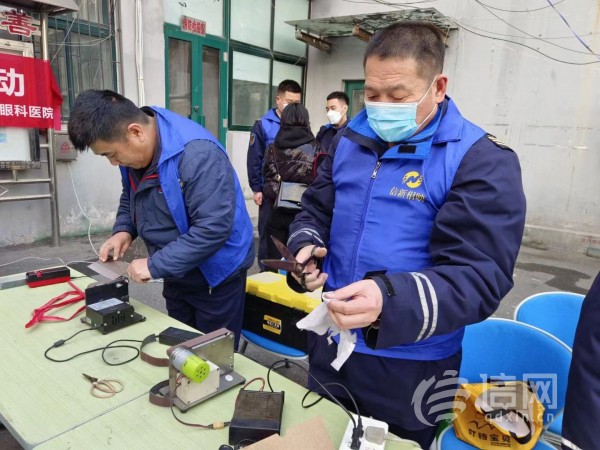 志愿者为居民提供磨刀服务。(来源：信网 首席记者 丛黎 摄)