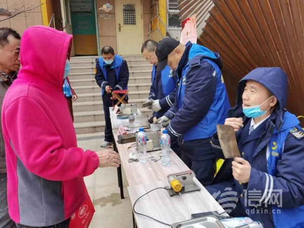 志愿者为居民提供磨刀服务(来源：信网 首席记者 丛黎 摄)