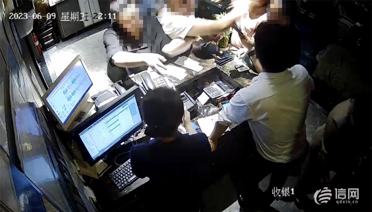 酒店监控视频显示一名戴眼镜的男子打了收银台后面的男子。(来源：青岛良友味道酒店)