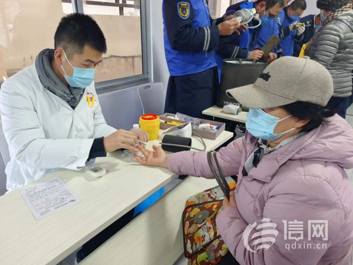 志愿者为居民测量血糖。(来源：信网 首席记者 丛黎 摄)