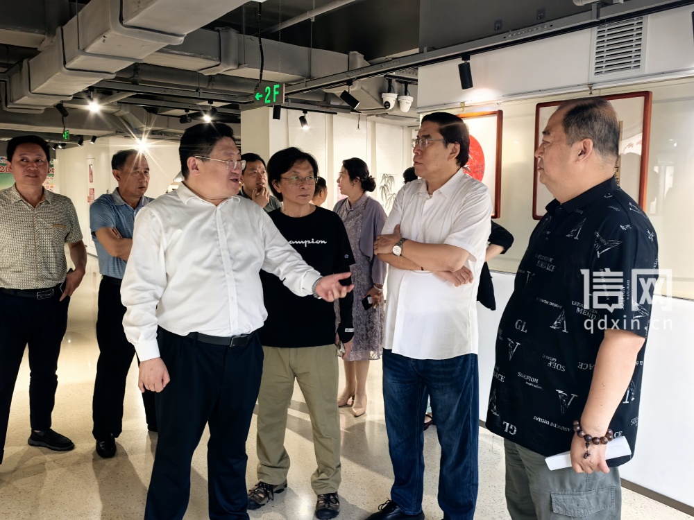 张学正（右一）与参观展览的嘉宾互动交流（来源：信网）