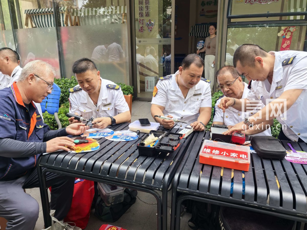 志愿者曲洪亭、王君、王德亭、綦国民、刘永强（从左至右）为居民维修小家电。（来源：信网）