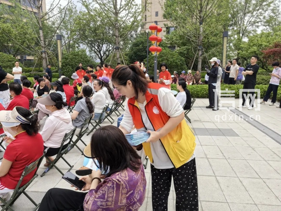 工作人员向居民发放《崂记文明》宣传册。（来源：金家岭街道办）