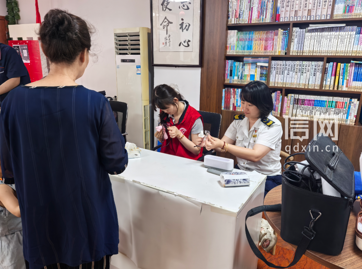 志愿者尘羽浓（左）、衣俊鑫（右）为居民清洗眼镜。（来源：信网）