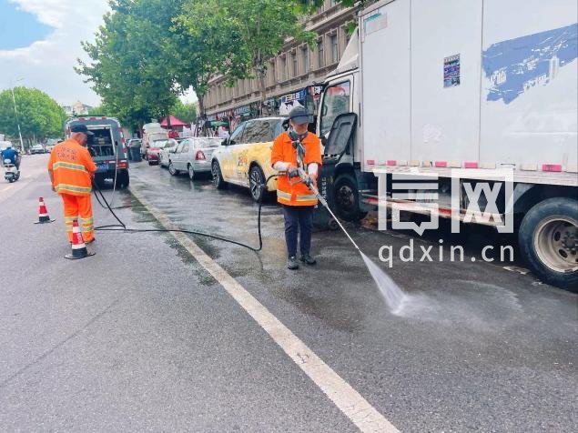 环卫人员冲洗道路。（来源：青岛市城市管理局）