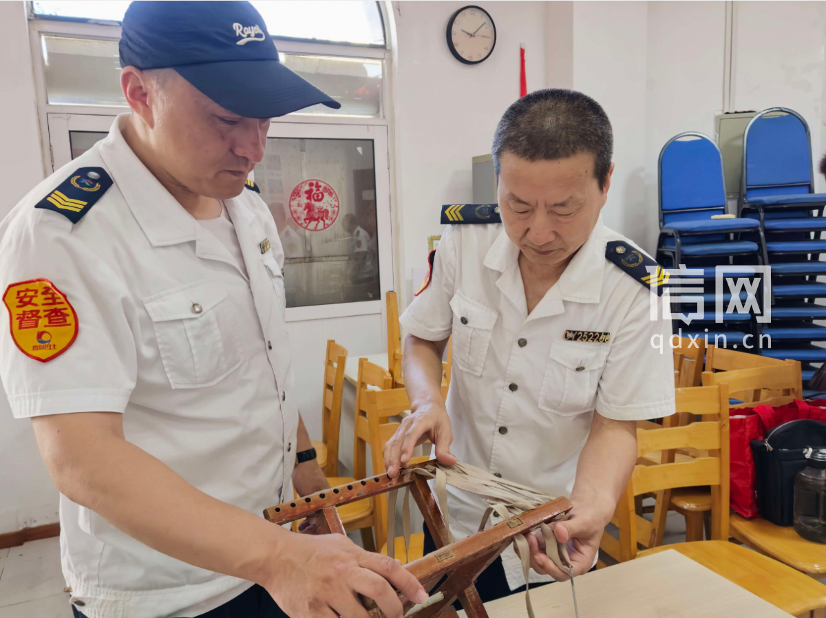 志愿者刘帅(左)、于爱忠(右)为居民穿马扎。(来源:信网)
