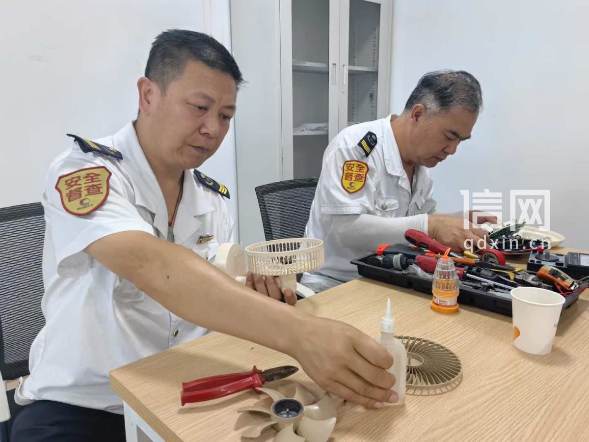 志愿者王君（左）、管恩国（右）为居民维修小家电。（来源：信网）