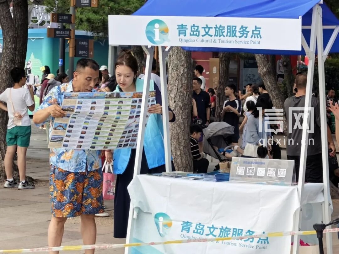 志愿者在服务点为游客耐心解答咨询。（来源：青岛市文化和旅游局）