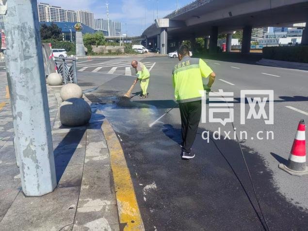 环卫人员冲洗路面。（来源：青岛市城市管理局）