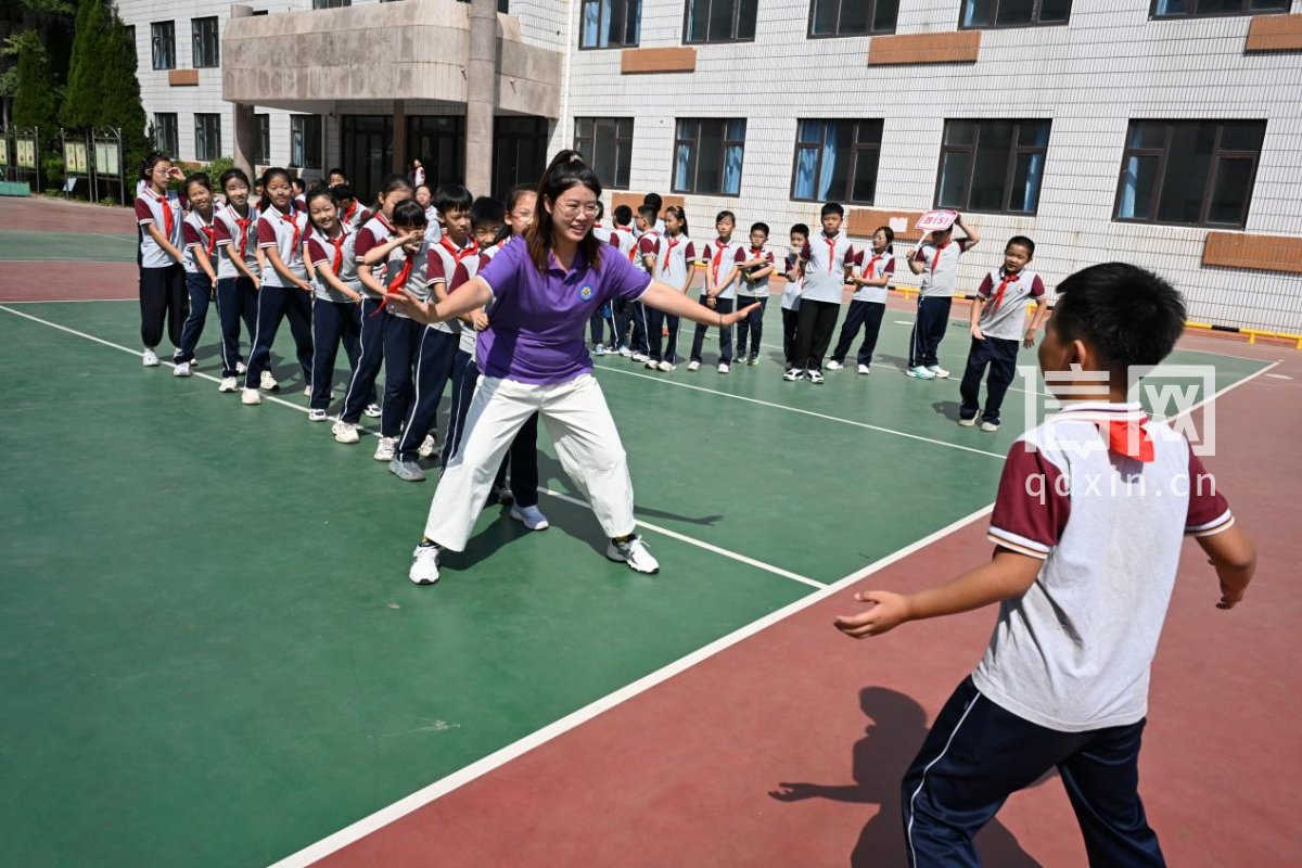 老师带领学生们在课间玩“老鹰抓小鸡”游戏。（来源：即墨区委宣传部）