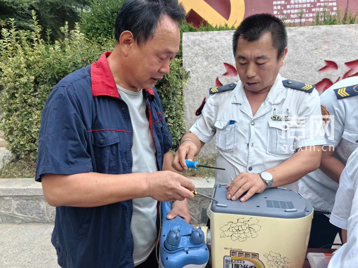 志愿者冯汉金（左）、刘永强（右）为居民维修小家电。（来源：信网）