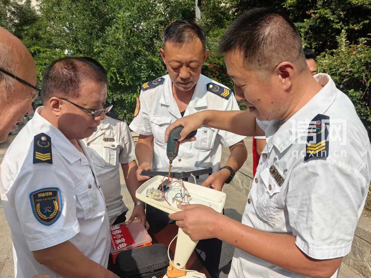 志愿者綦国民、李滨、黄佳峰（从左至右）为居民维修小家电。（来源：信网）