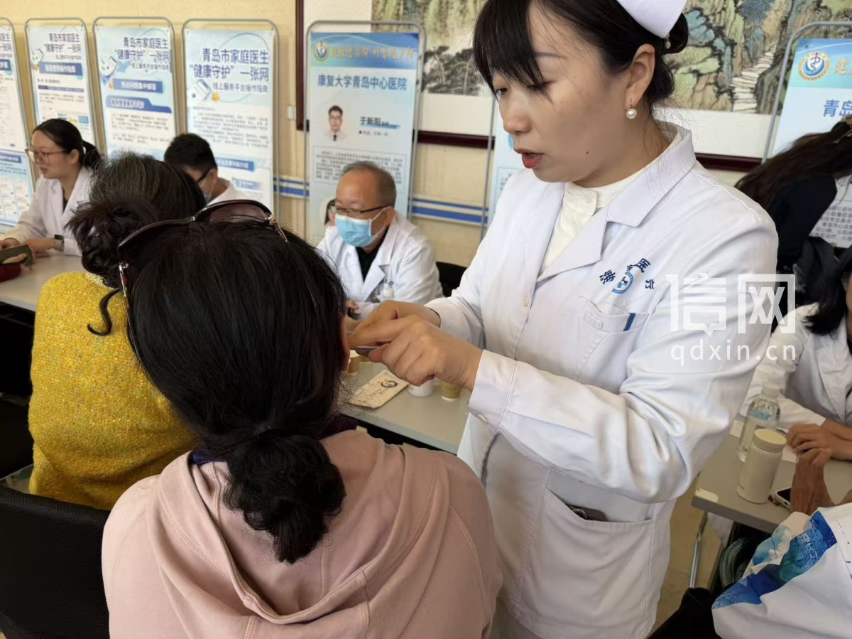 市民现场体验耳穴压豆中医疗法。（来源：信网 丛黎 摄）